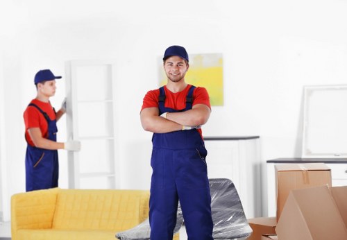 Professional movers carrying furniture through a West London property